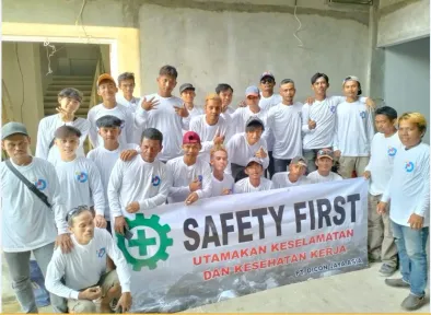 Tim yang lebih besar membentangkan spanduk yang sama di dalam bangunan yang belum selesai, dindingnya masih polos.