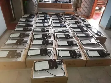 Puluhan lampu jalan LED tertata di atas kardusnya di dalam ruangan, menunggu pemasangan.